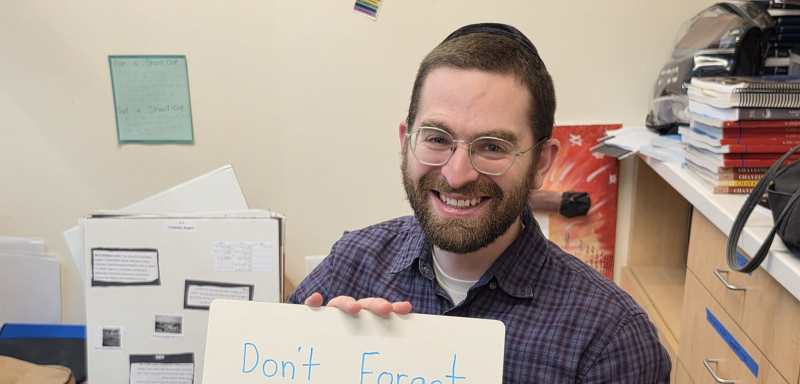 Teacher holding encouraging paper sign