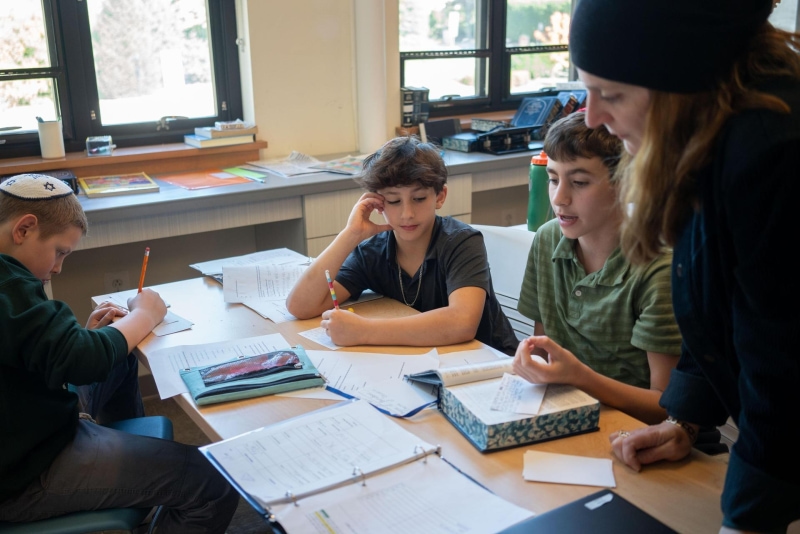 Teacher helping students at table