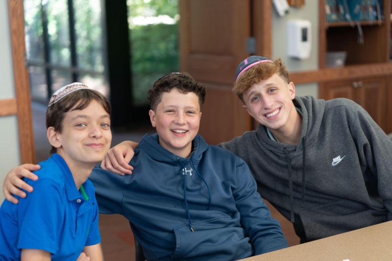Three boys smiling together indoors
