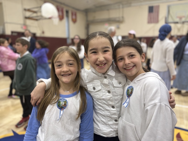 Three girls smiling indoors together